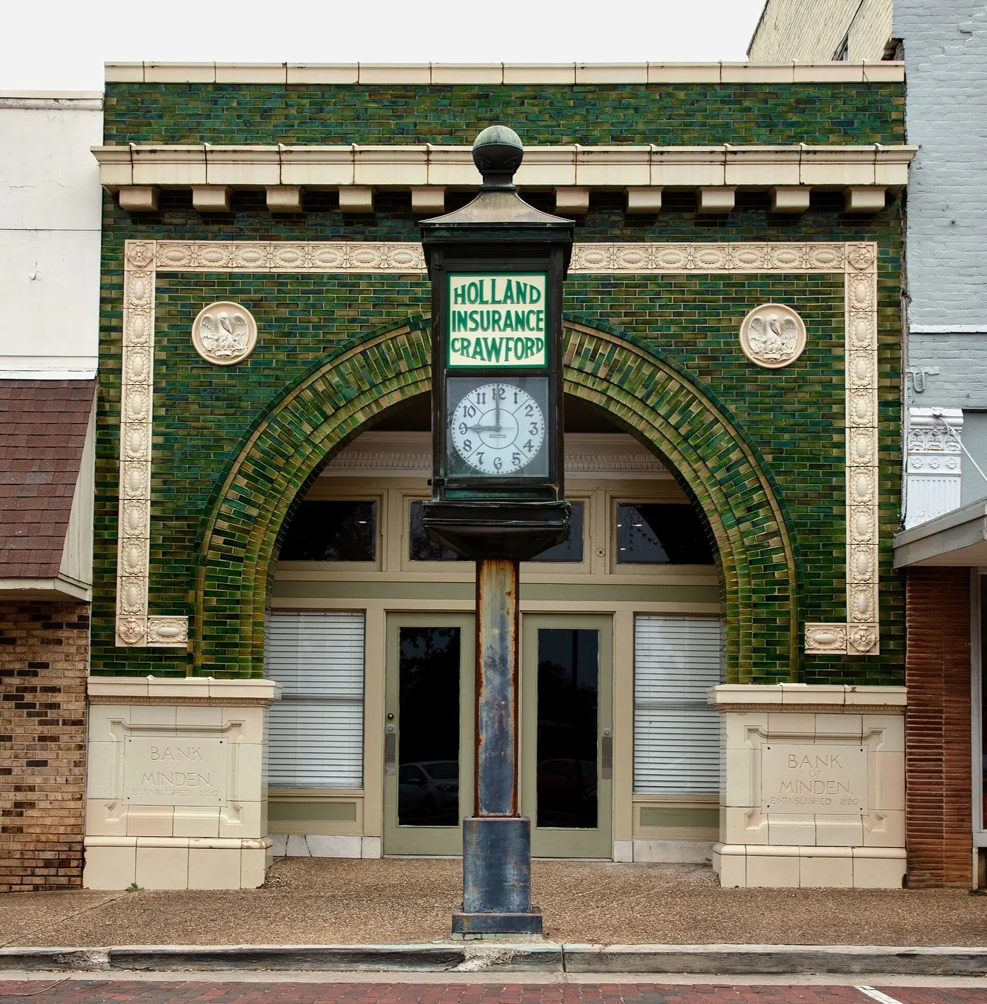The Bank of Minden in Louisiana, with a street clock in front of the tiled entrance