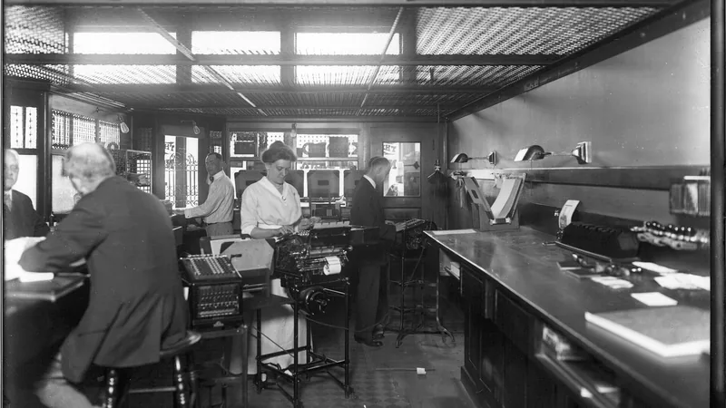 No copyright restriction Clerks and adding machines behind the teller line at the Oxford National Bank in Oxford, Ohio, photographed in 1916.