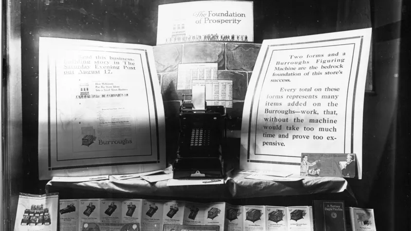 No copyright restriction A 1916 bank-window display of a Burroughs figuring machine and printed forms.