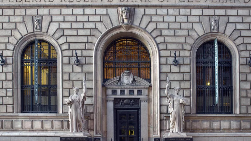 The stone entrance of the Federal Reserve Bank of Cleveland, with Learning Center and Money Museum banners in the arched windows.