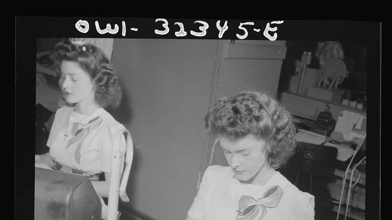 Two clerks paste and sort telegram strips at a Western Union office in Washington in 1943.