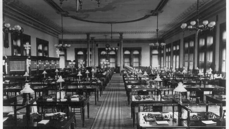 The general operating department of the Western Union Telegraph Building in New York, with rows of desks and shaded lamps.