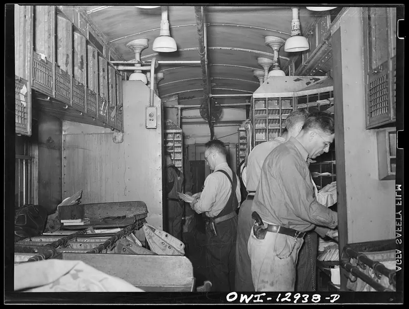 Clerks sort letters into pigeonholes on a railway mail car in 1938.
