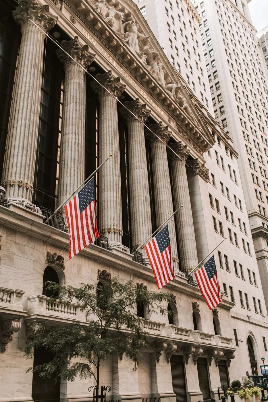 The New York Stock Exchange facade with stone columns and American flags