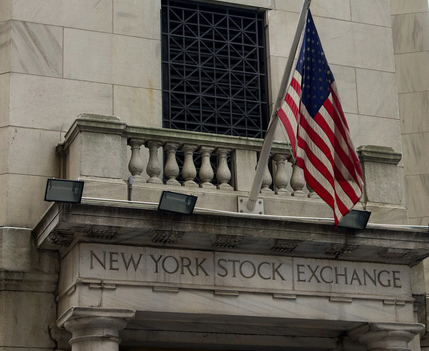 No copyright restriction Stone lettering for the New York Stock Exchange above the entrance, with a hanging flag.