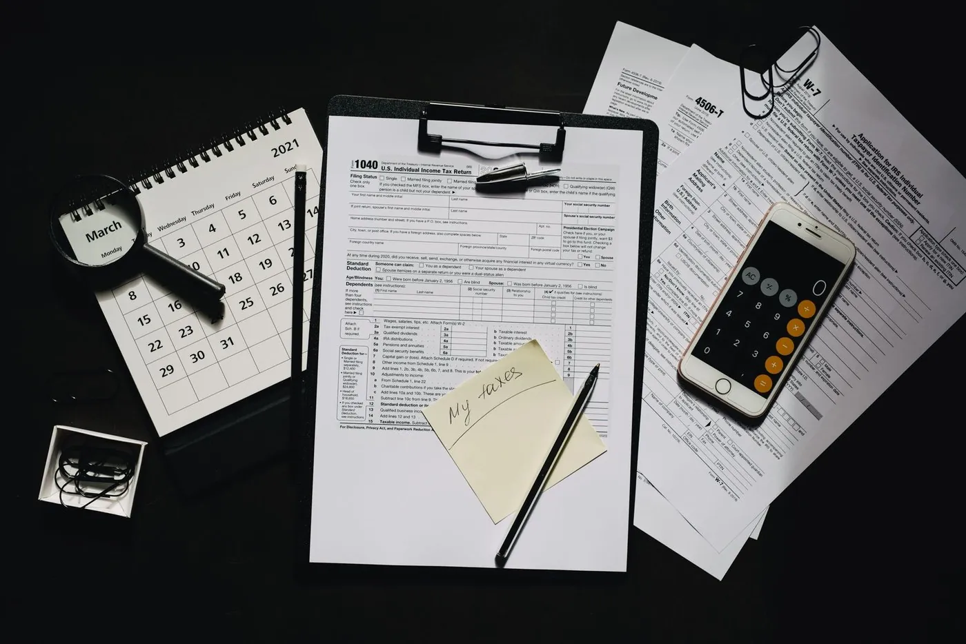 No copyright restriction A desk with a tax form on a clipboard, a paper calendar, and a phone calculator.